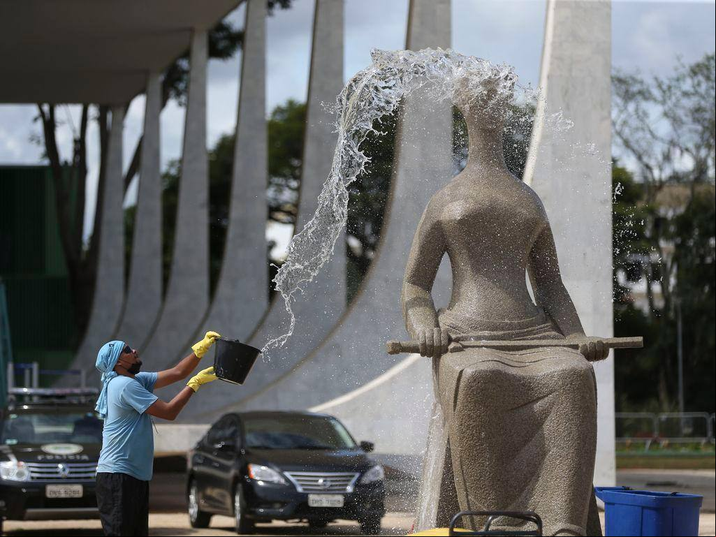 Funcionário faz a lavagem da estátua da Justiça em frente ao STF: obra de arte foi alvo de vândalos em 8 de janeiro